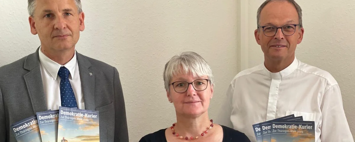 Superintendent Tobias Steinke, Superintendentin Annette von Biela und Superintendent Hendrik Mattenklodt (v.l.) mit dem Demokratie-Kurier (EKM)