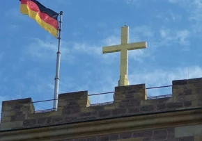 Das vergoldete Kreuz auf dem Bergfried der Wartburg sowie die Fahne der Bundesrepublik Deutschland (Wikipedia) | Foto: Wikipedia