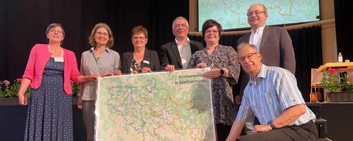 Präsides und Leitungspersonen der vier Kirchenkreise in Südthüringen mit Karte des neuen Kirchenkreises (©Ralf Gebauer)